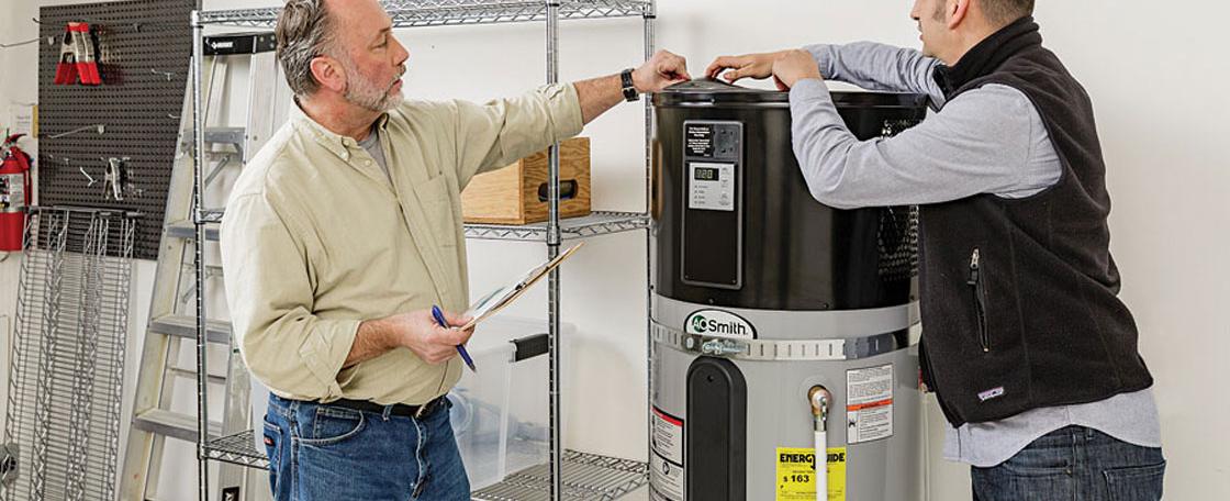 Two people speaking next to a heat pump water heater